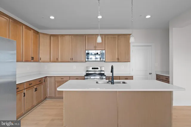 a kitchen with stainless steel appliances granite countertop a sink stove and cabinets