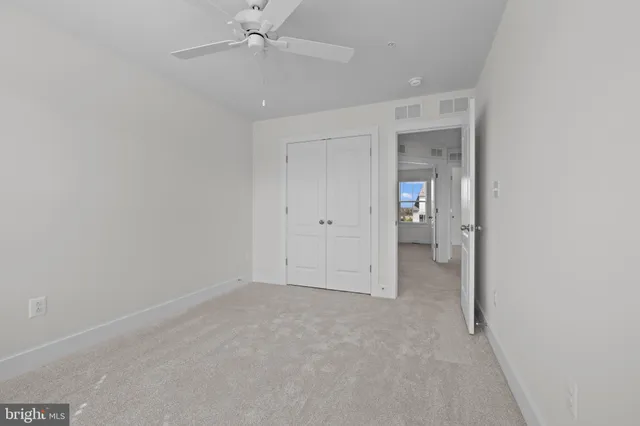 an empty room with fan and entrance