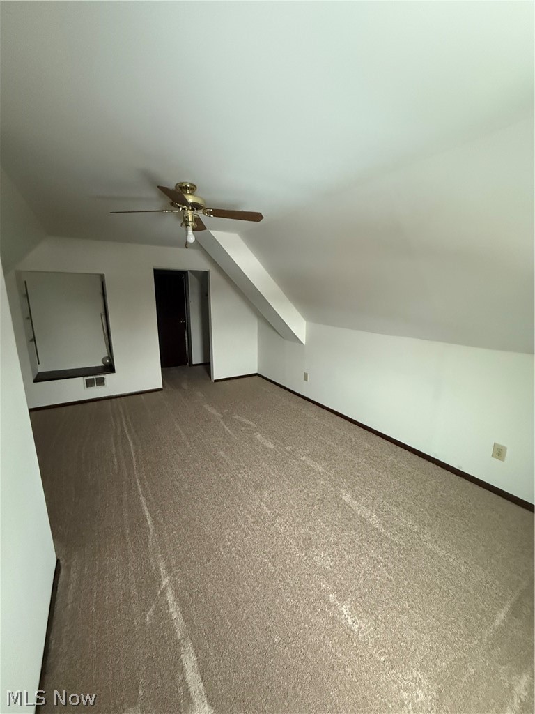 3612 Riverside Avenue Cleveland, OH 44109 - Photo 20 of 22 Spacious carpeted room featuring a ceiling fan, sloped ceilings, and a built-in wall niche