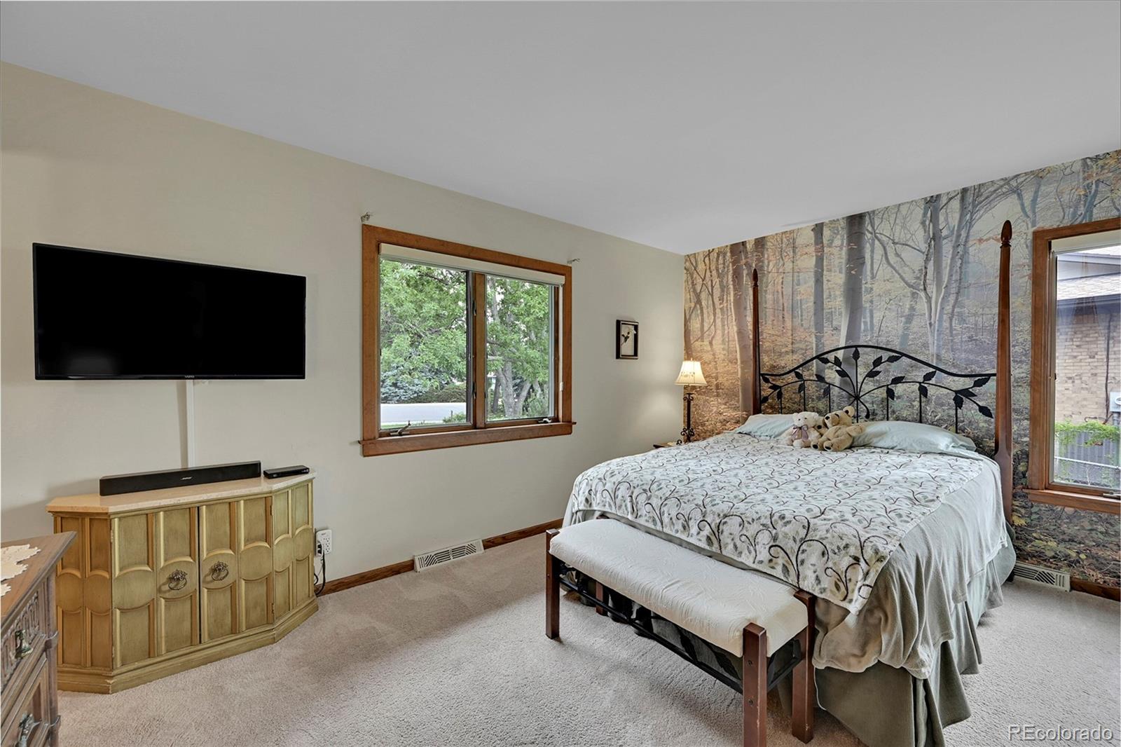 12377 West Louisiana Avenue Lakewood, CO 80228 - Photo 19 of 50 a bedroom with a bed and a flat tv screen on dresser