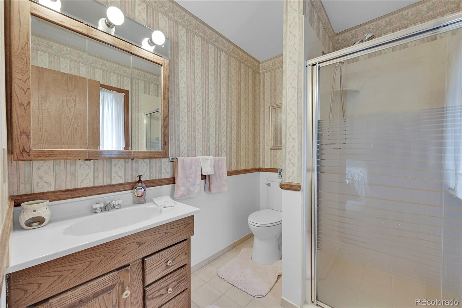 12377 West Louisiana Avenue Lakewood, CO 80228 - Photo 21 of 50 a bathroom with a sink a toilet and shower
