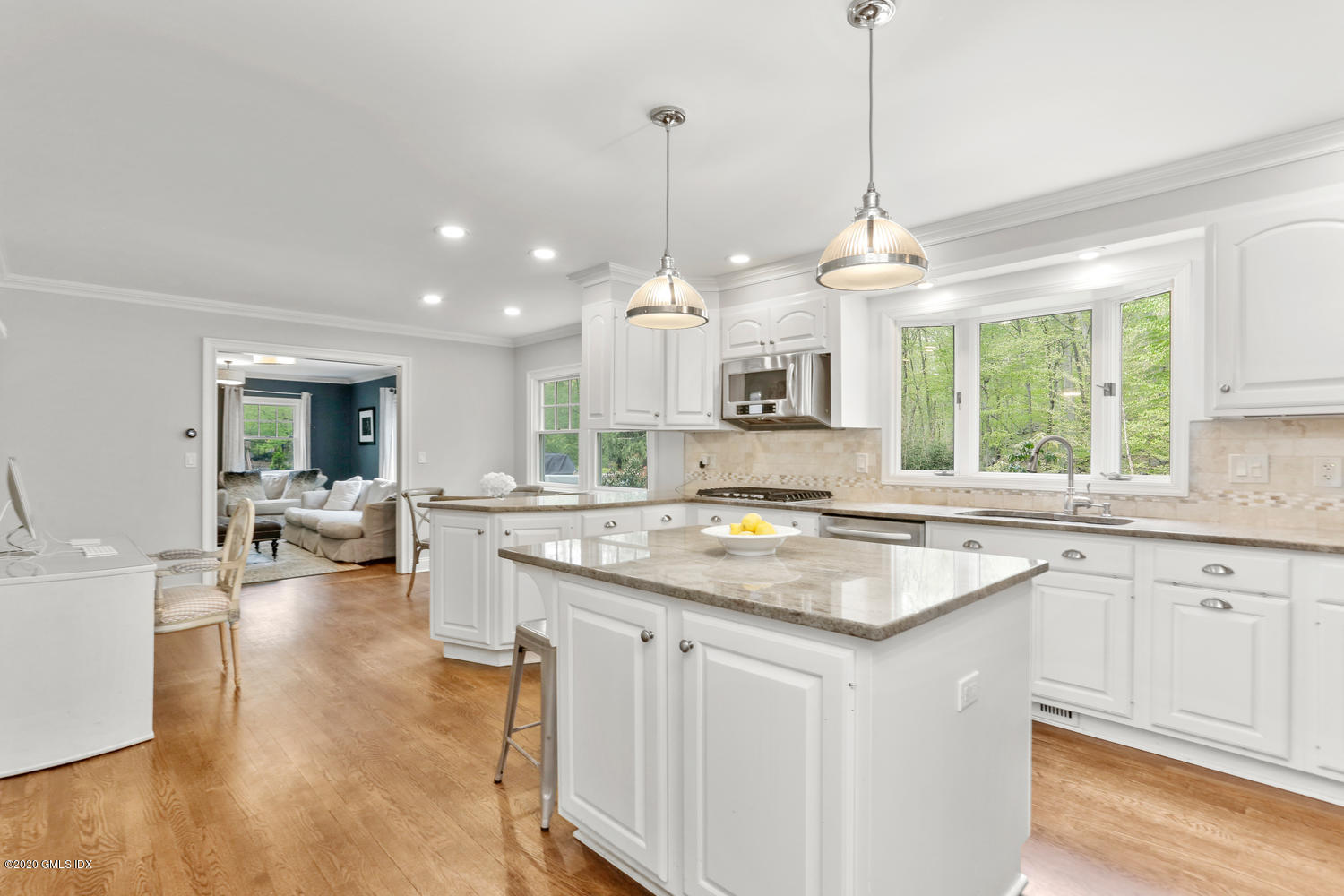 277 Cognewaugh Road Cos Cob, CT 06807 - Photo 11 of 34 a kitchen with a center island white cabinets and a wooden floor