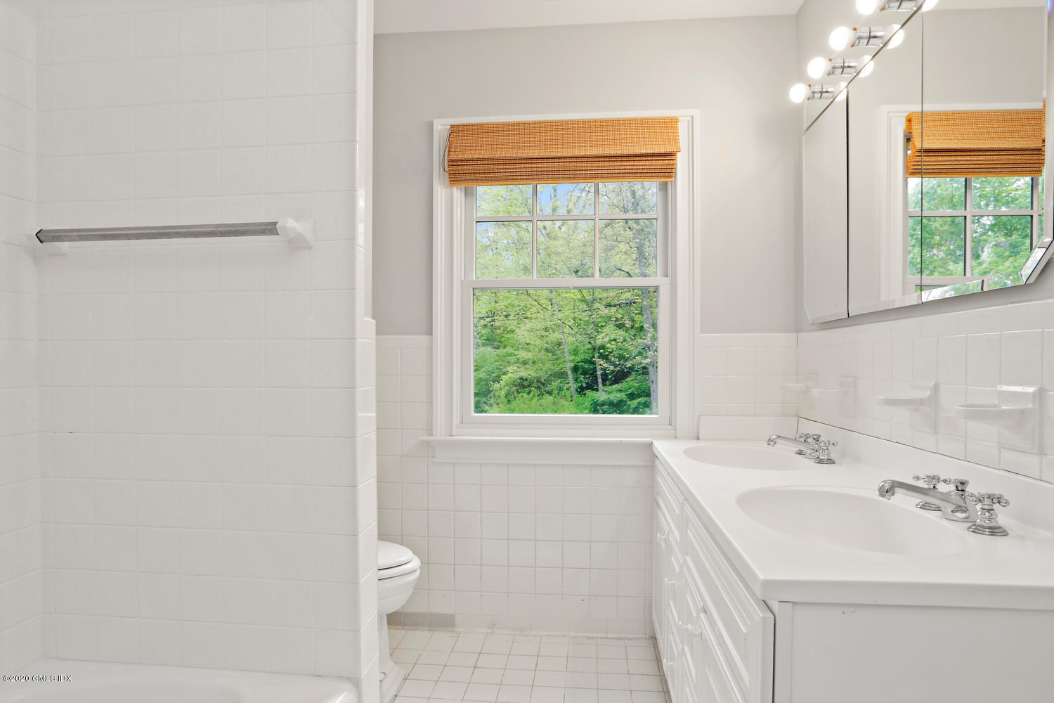 277 Cognewaugh Road Cos Cob, CT 06807 - Photo 23 of 34 a bathroom with a sink a toilet and a window