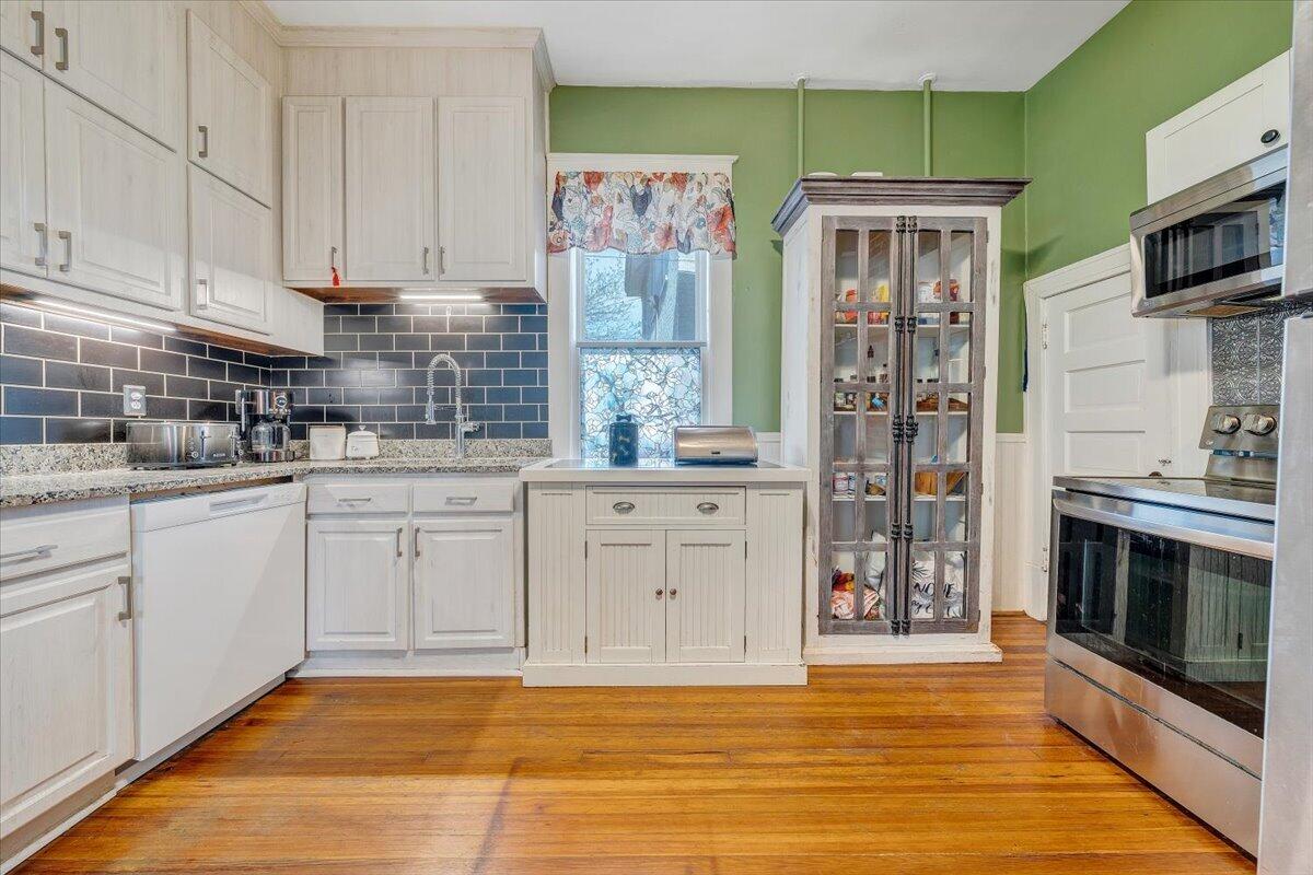 1307 Maple Avenue Southwest Roanoke, VA 24016 - Photo 25 of 53 a kitchen with stainless steel appliances white cabinets and a stove top oven