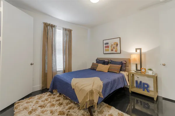 a bedroom with a bed and wooden floor