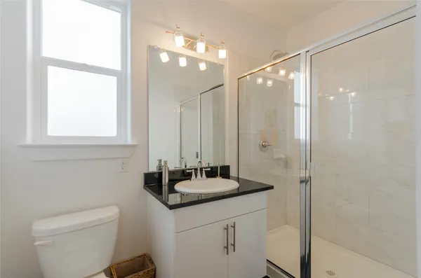 a bathroom with a sink a toilet a shower and a mirror