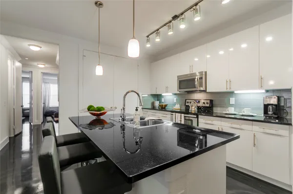 a kitchen with stainless steel appliances granite countertop a sink a stove and a refrigerator
