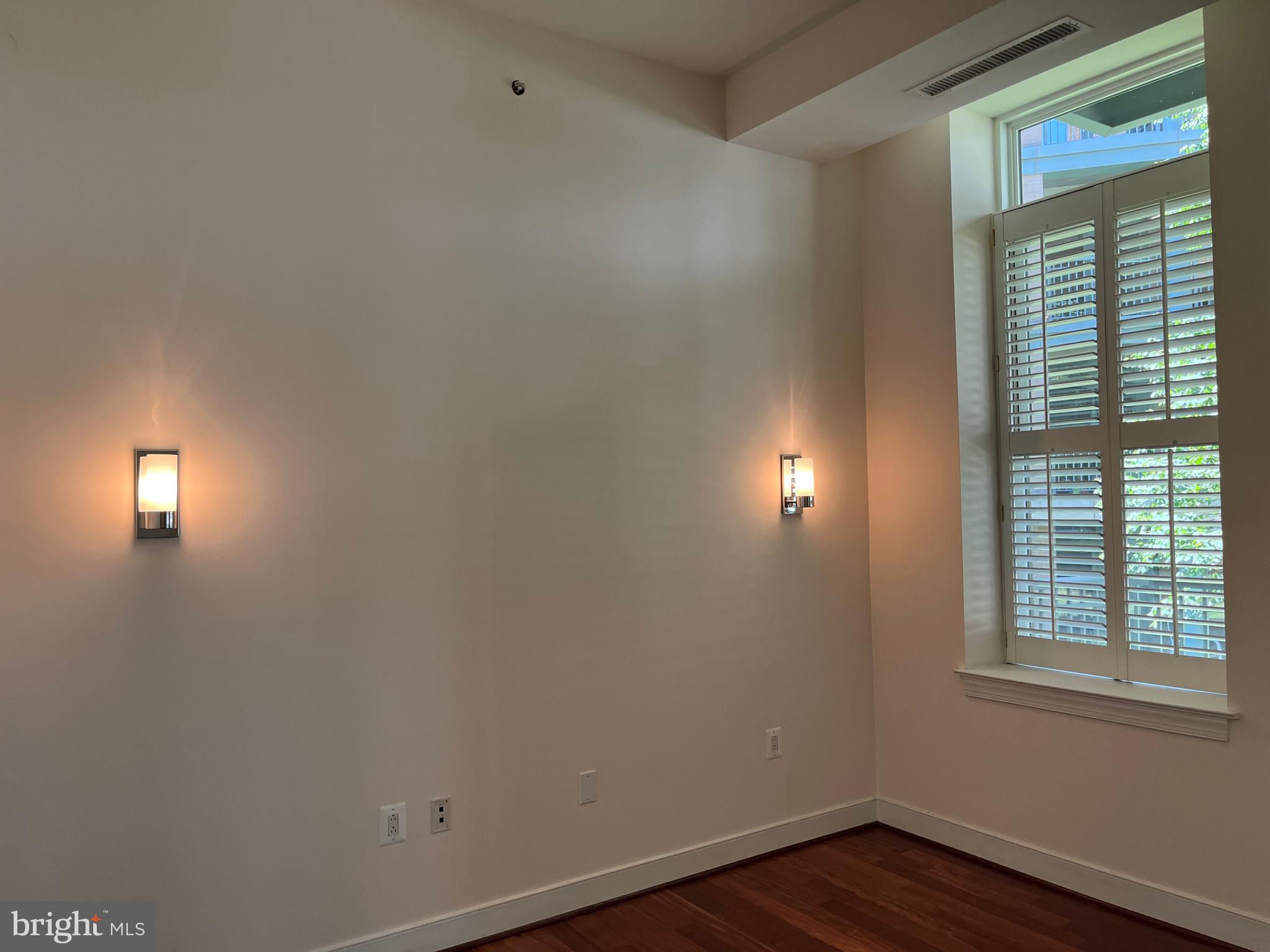 2425 L Street Northwest, Unit 215 Washington, DC 20037 - Photo 12 of 38 an empty room with wooden floor and windows