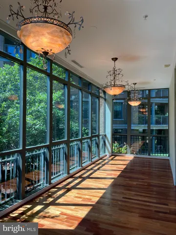 a view of a living room and floor to ceiling windows with wooden floor