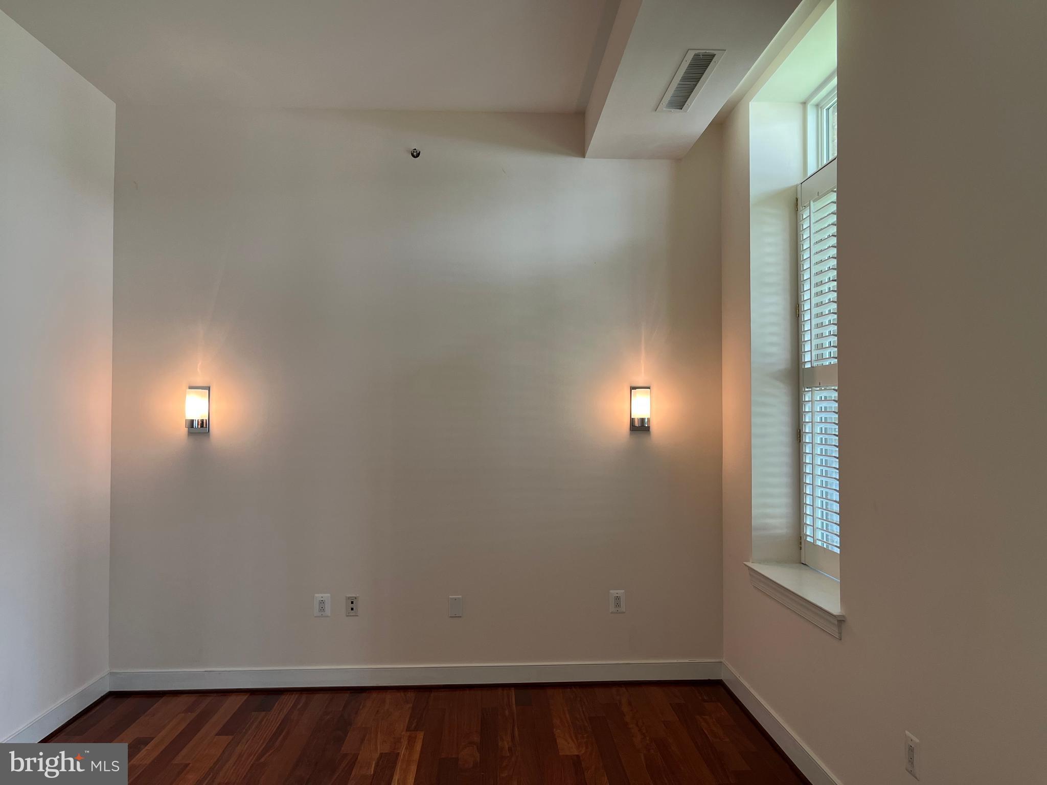 2425 L Street Northwest, Unit 215 Washington, DC 20037 - Photo 21 of 38 an empty room with wooden floor and windows