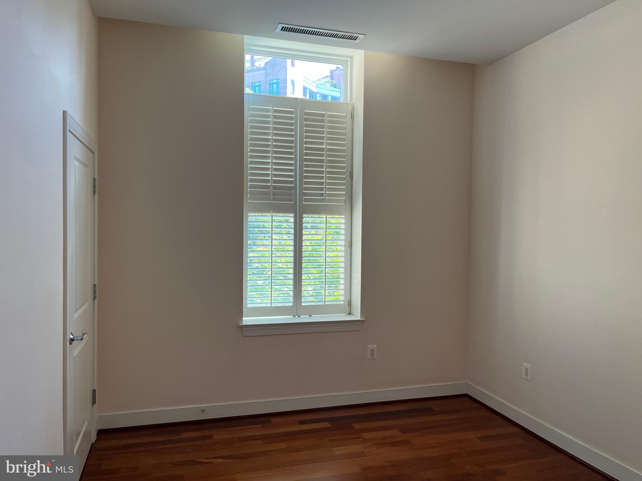 2425 L Street Northwest, Unit 215 Washington, DC 20037 - Photo 26 of 38 an empty room with wooden floor and windows