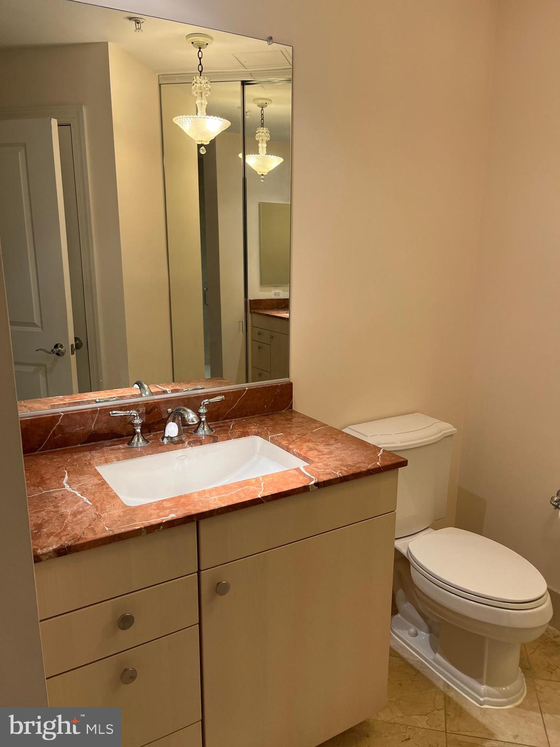 2425 L Street Northwest, Unit 215 Washington, DC 20037 - Photo 27 of 38 a bathroom with a granite countertop sink and a mirror