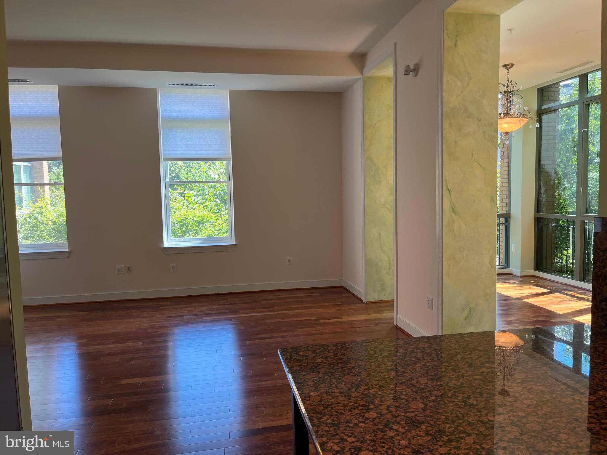 2425 L Street Northwest, Unit 215 Washington, DC 20037 - Photo 10 of 38 a view of an empty room with wooden floor and a window
