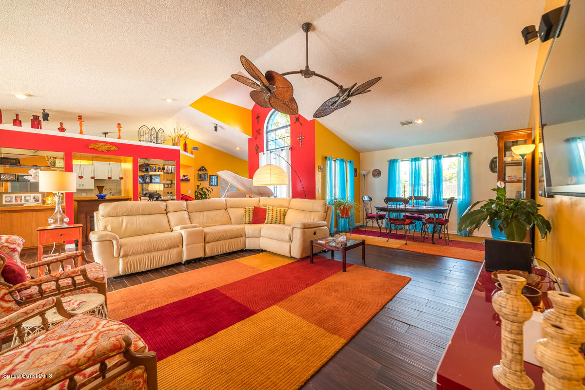 1508 Meadowbrook Road Northeast Palm Bay, FL 32905 - Photo 17 of 42 a living room with furniture a rug and a chandelier