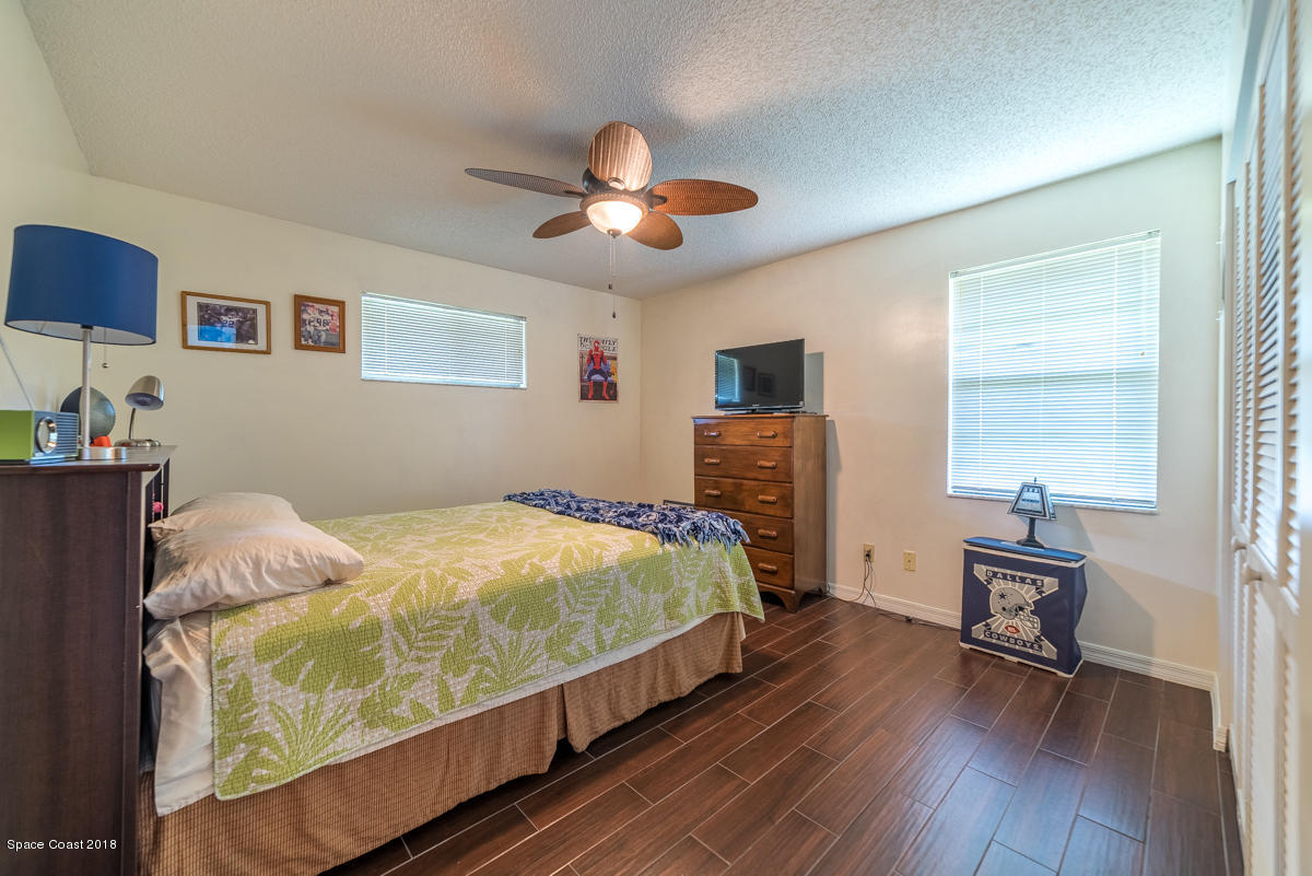 1508 Meadowbrook Road Northeast Palm Bay, FL 32905 - Photo 20 of 42 a bed room with a bed and a chair