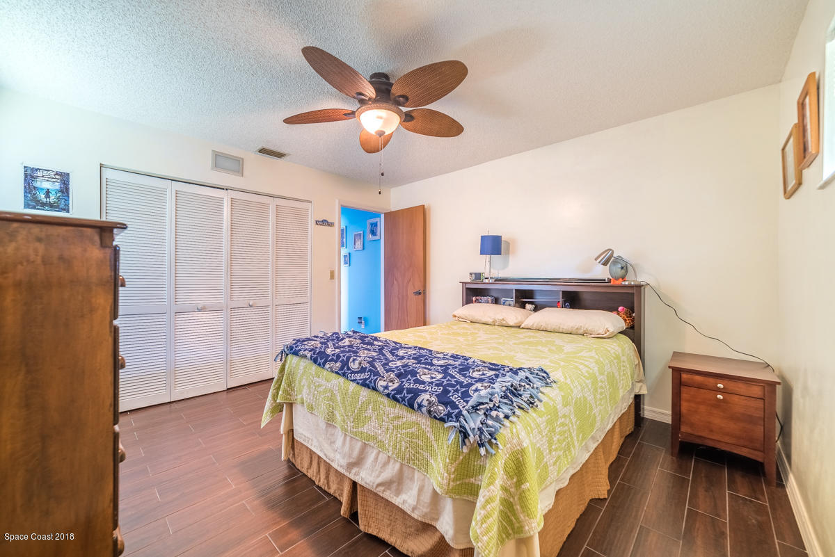 1508 Meadowbrook Road Northeast Palm Bay, FL 32905 - Photo 21 of 42 a bedroom with a bed and a chandelier