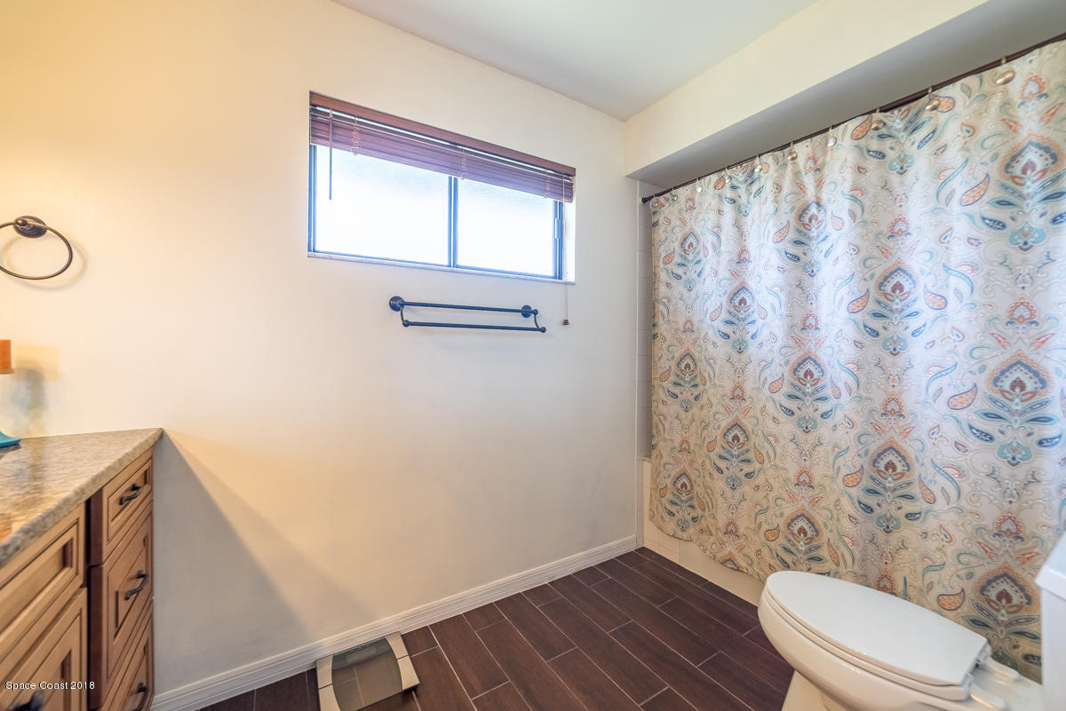 1508 Meadowbrook Road Northeast Palm Bay, FL 32905 - Photo 23 of 42 a bathroom with a toilet and a shower curtain