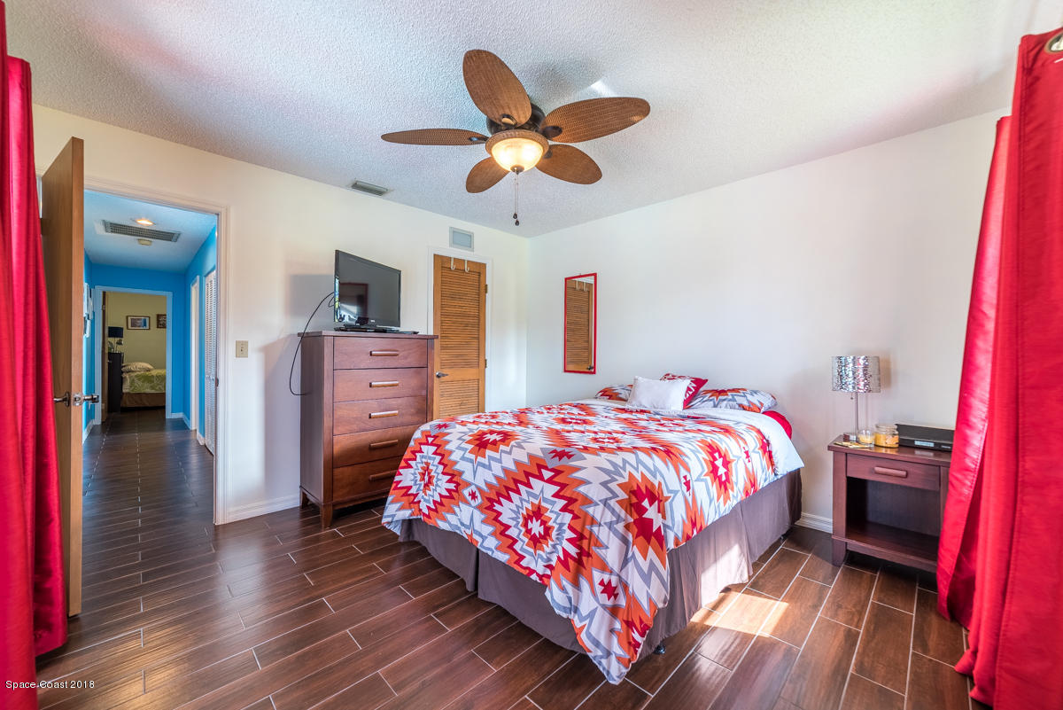 1508 Meadowbrook Road Northeast Palm Bay, FL 32905 - Photo 24 of 42 a bedroom with a bed and a chandelier