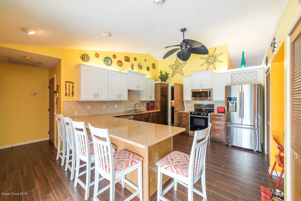 1508 Meadowbrook Road Northeast Palm Bay, FL 32905 - Photo 25 of 42 a kitchen with stainless steel appliances granite countertop a sink and a refrigerator