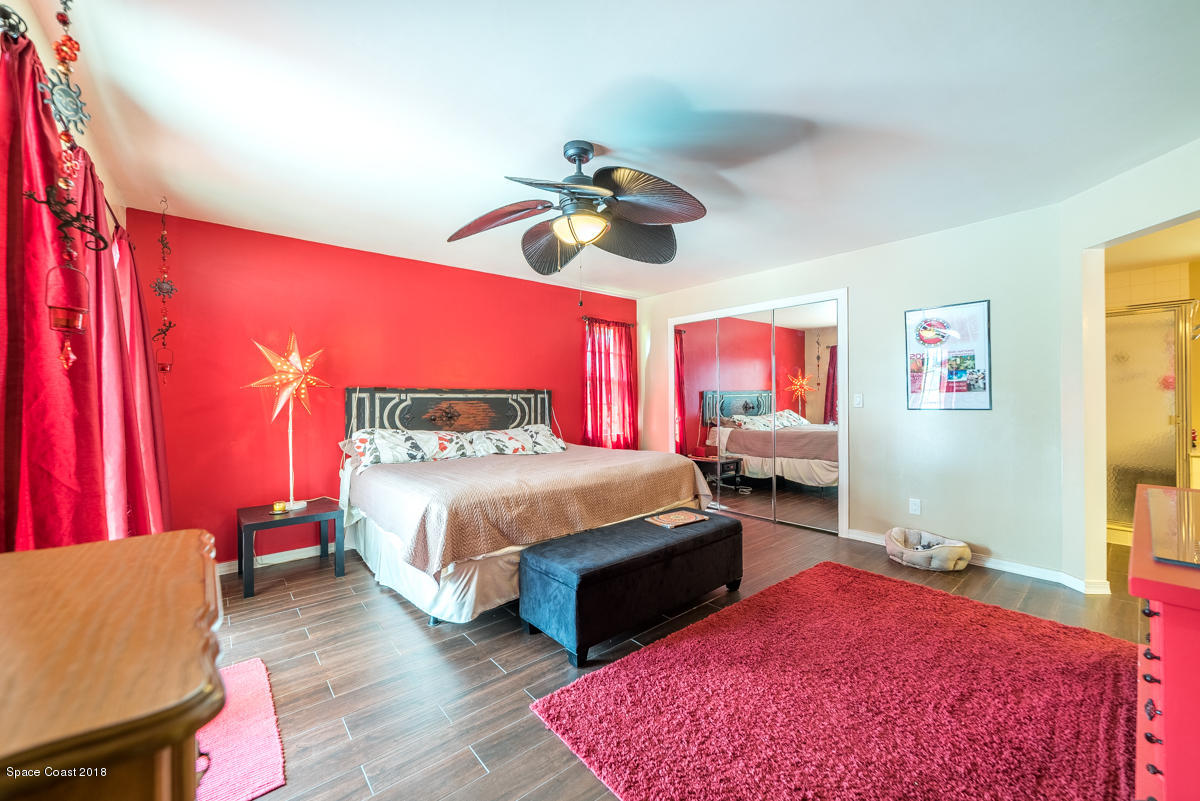 1508 Meadowbrook Road Northeast Palm Bay, FL 32905 - Photo 29 of 42 a bedroom with a bed and dresser with mirror