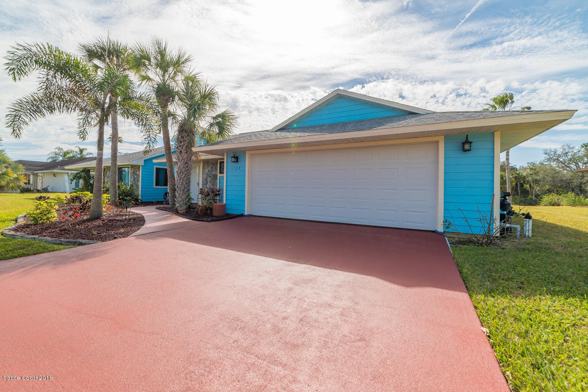 1508 Meadowbrook Road Northeast Palm Bay, FL 32905 - Photo 4 of 42 a front view of a house with a yard and garage