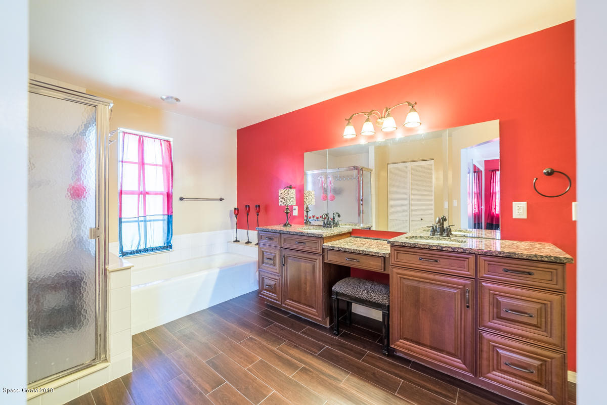 1508 Meadowbrook Road Northeast Palm Bay, FL 32905 - Photo 33 of 42 a bathroom with a granite countertop sink and a mirror