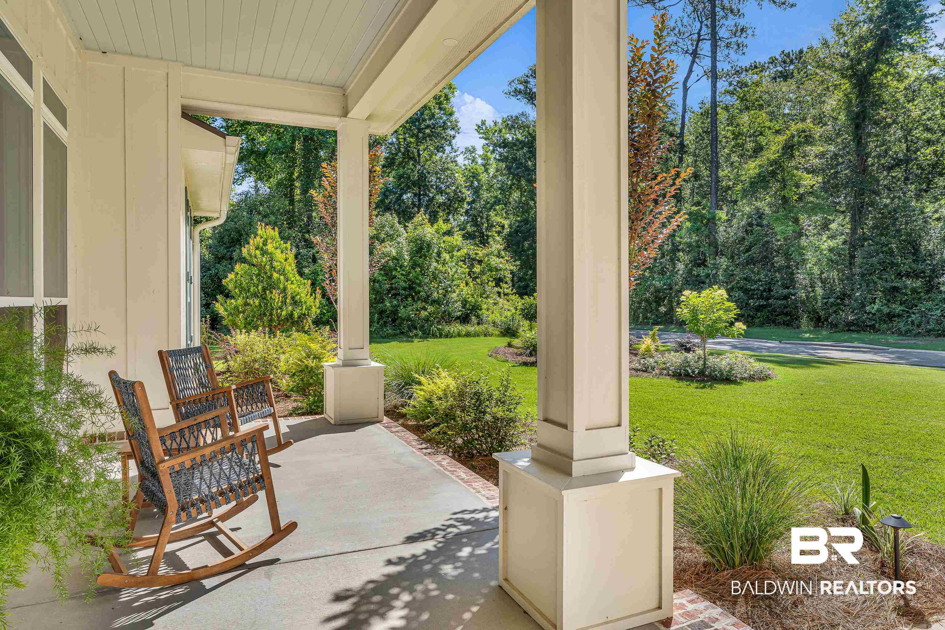 17541 Polo Ridge Boulevard Fairhope, AL 36532 - Photo 3 of 19 Expansive covered front porch featuring a concrete surface, painted support columns, and an exterior siding facade