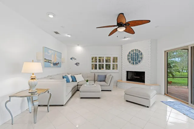 a living room with furniture fireplace and a large window
