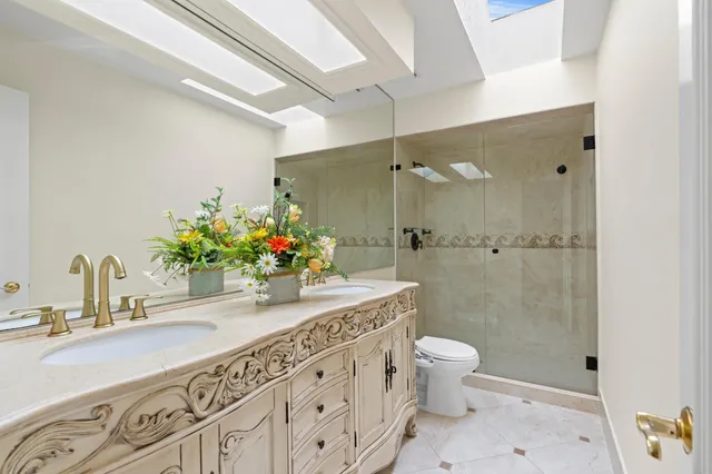 a bathroom with a granite countertop sink toilet and shower
