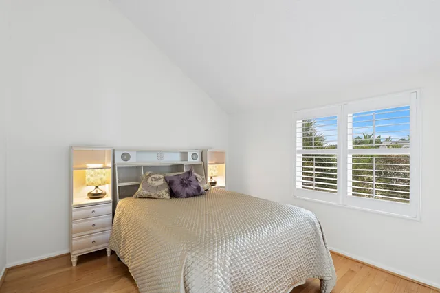 a bedroom with a bed and a flat tv screen on a dresser
