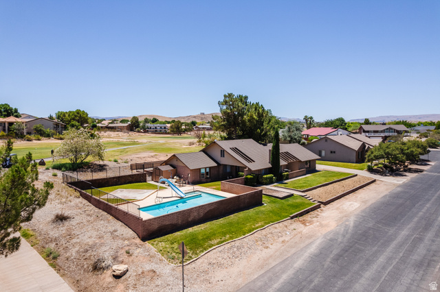 1470 Redwood Tree Street St. George, UT 84790 - Photo 39 of 53 Exterior featuring a swimming pool with a slide, surrounded by a brick fence and a grass lawn