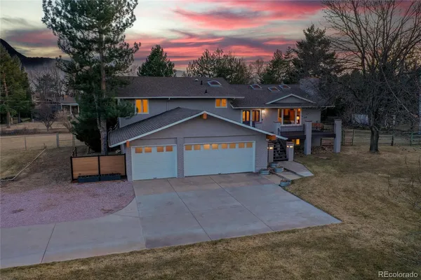 an aerial view of a house with a yard and a large tree