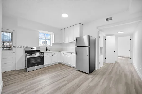a kitchen with a refrigerator and a stove top oven