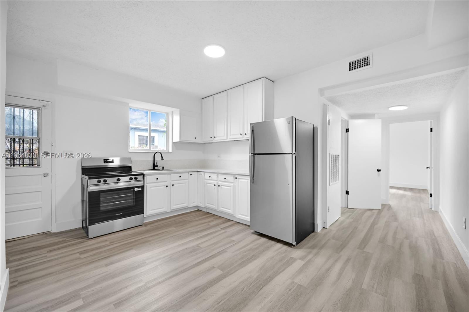 a kitchen with a refrigerator and a stove top oven