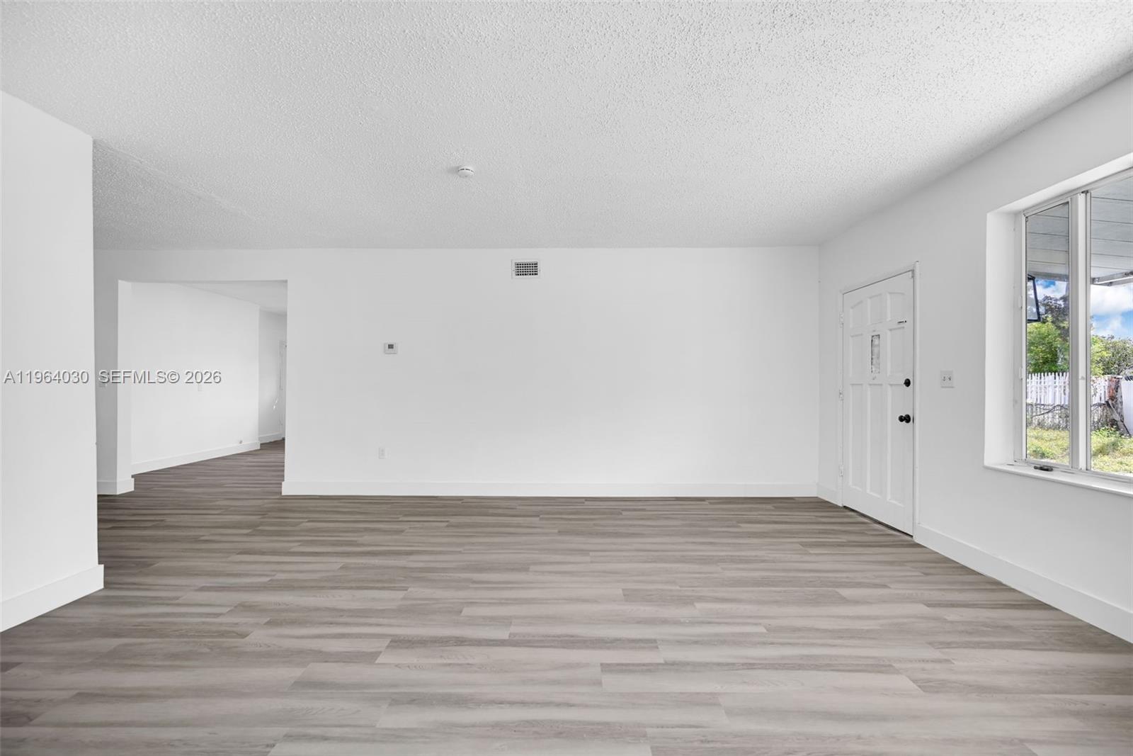 1391 Northwest 102nd Street, Unit 1391 Miami, FL 33147 - Photo 11 of 32 a view of an empty room with wooden floor and a window