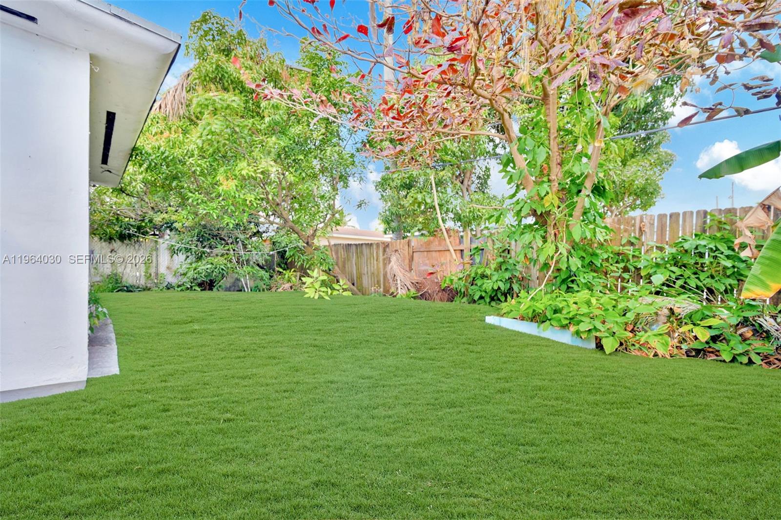 1391 Northwest 102nd Street, Unit 1391 Miami, FL 33147 - Photo 18 of 32 a backyard of a house with lots of green space and garden