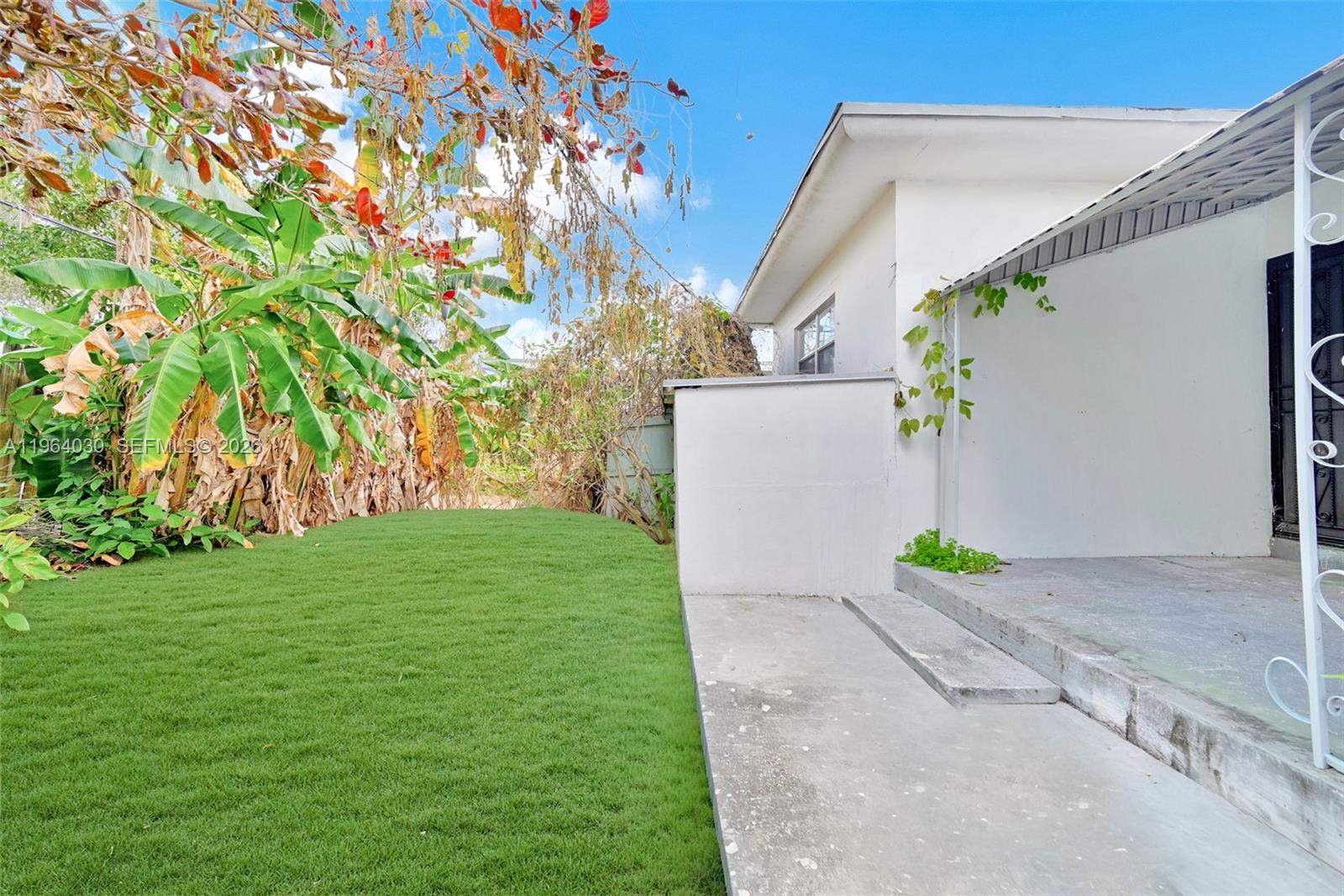 1391 Northwest 102nd Street, Unit 1391 Miami, FL 33147 - Photo 19 of 32 a backyard of a house with lots of green space and trees in the back