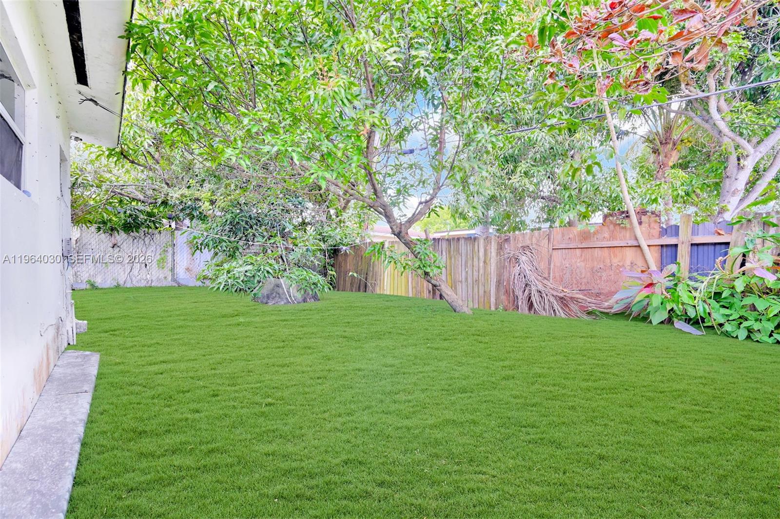 1391 Northwest 102nd Street, Unit 1391 Miami, FL 33147 - Photo 20 of 32 a view of a backyard with large trees
