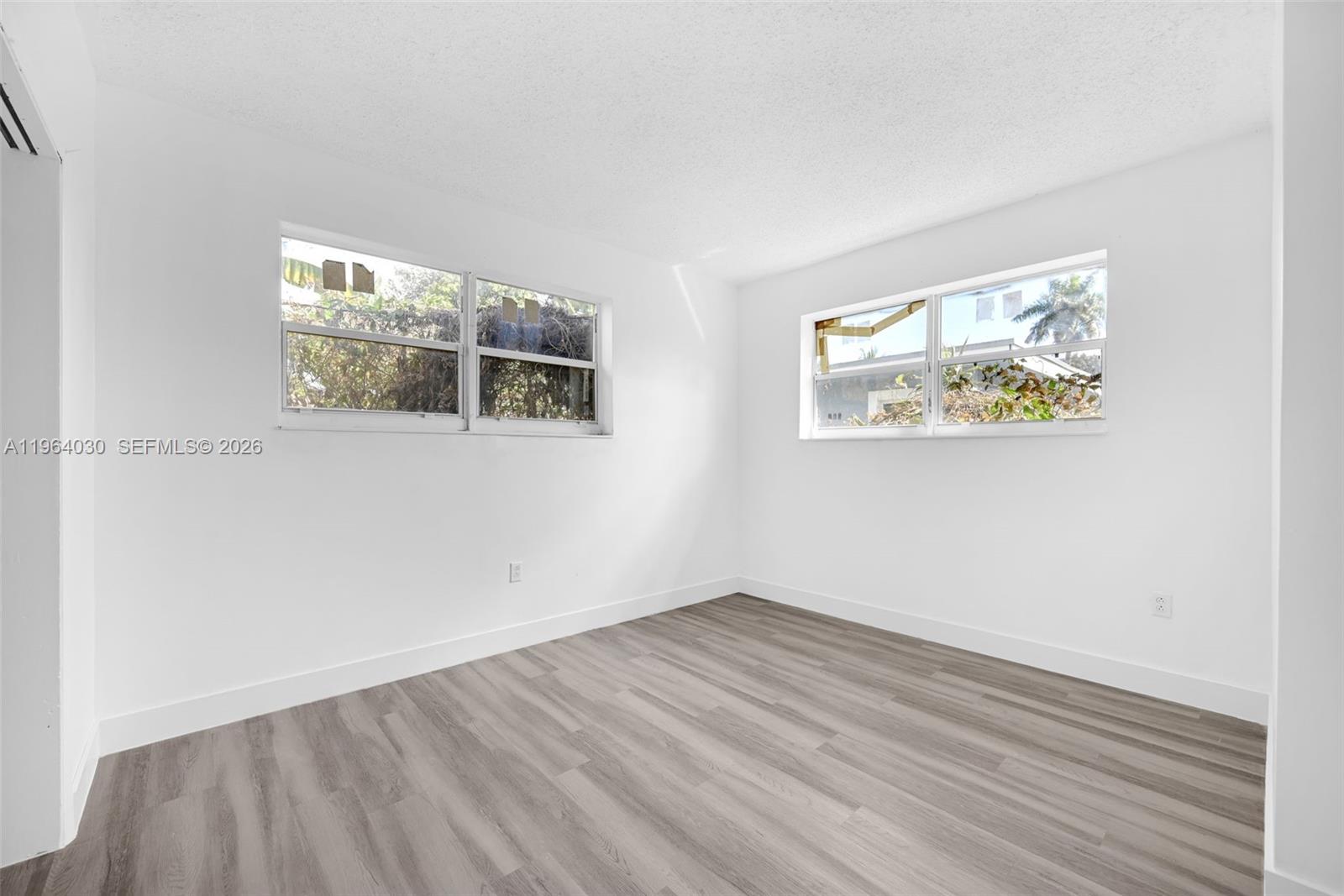 1391 Northwest 102nd Street, Unit 1391 Miami, FL 33147 - Photo 24 of 32 an empty room with wooden floor and window