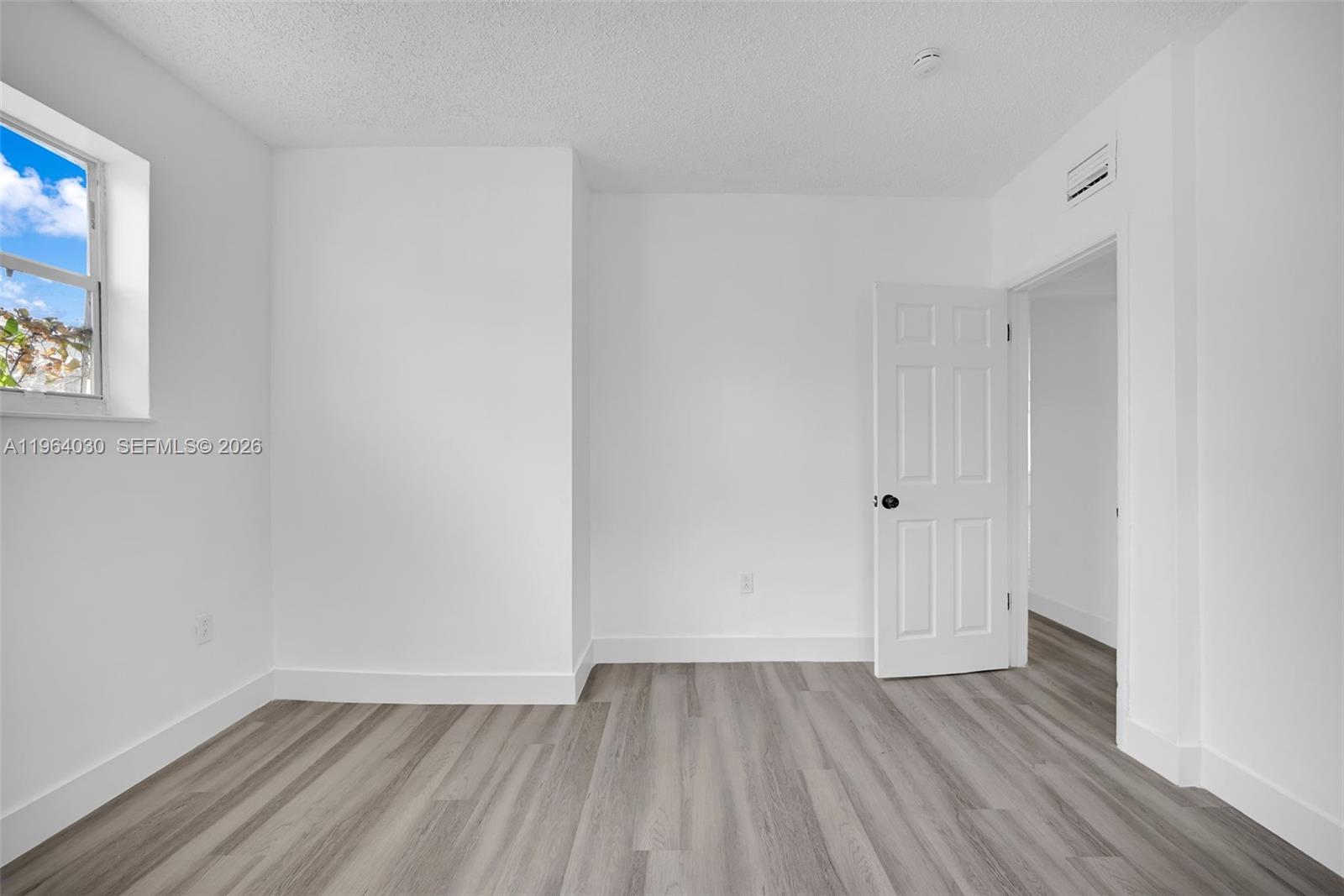 1391 Northwest 102nd Street, Unit 1391 Miami, FL 33147 - Photo 26 of 32 a view of an empty room with wooden floor and a window