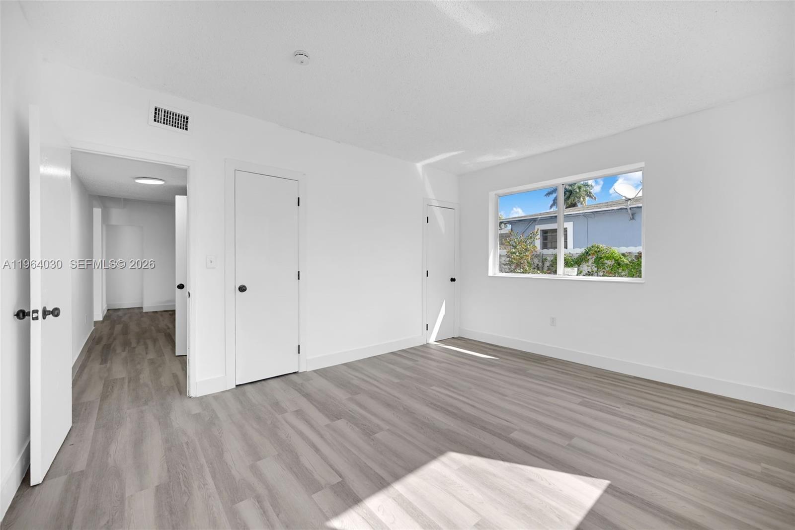 1391 Northwest 102nd Street, Unit 1391 Miami, FL 33147 - Photo 28 of 32 wooden floor in an empty room with a window
