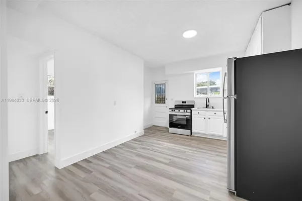 a kitchen with a refrigerator and a stove top oven