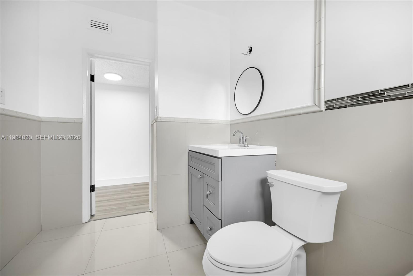 1391 Northwest 102nd Street, Unit 1391 Miami, FL 33147 - Photo 7 of 32 a bathroom with a toilet a sink and a mirror