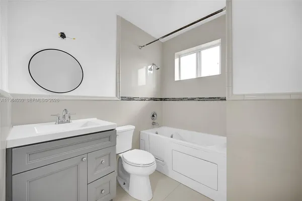 a bathroom with a toilet a sink a mirror and vanity