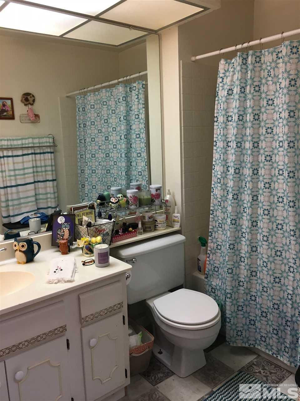 1611 Foster Drive Reno, NV 89509 - Photo 21 of 35 a bathroom with a sink a toilet and shower curtain