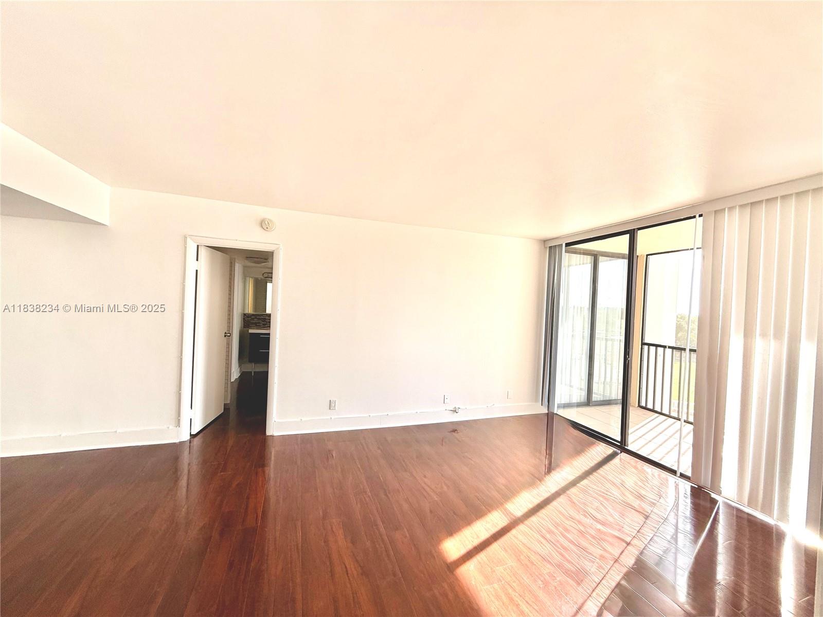 20335 West Country Club Drive, Unit 502 Aventura, FL 33180 - Photo 19 of 26 an empty room with wooden floor and windows