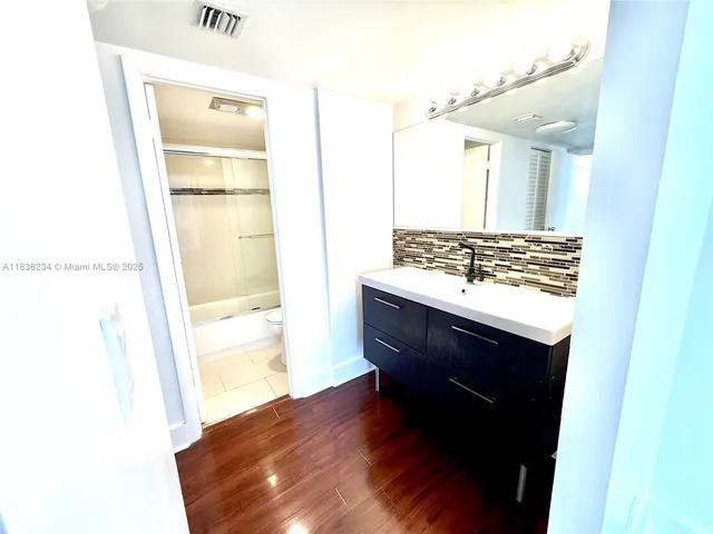a bathroom with a sink a mirror and a shower