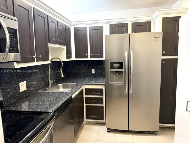 a kitchen with stainless steel appliances granite countertop a refrigerator and a sink