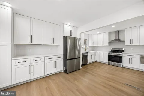 a kitchen with granite countertop white cabinets and stainless steel appliances