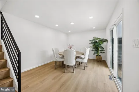 a dining room with furniture and a potted plant
